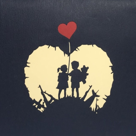 silhouettes of a young boy and girl as they stand with each other on a hill of weapons and instruments of mass destruction.